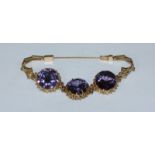 A yellow metal (tests as 18ct gold) bracelet set with three large Alexandrite coloured stones. Gross