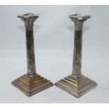 A pair of silver-plated candlesticks modelled as classical columns with composite capitals and