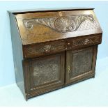 A carved Victorian oak bureau, the fall front opening to reveal a fitted interior with pigeonholes