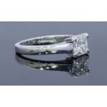 An 18ct white gold solitaire diamond ring, centrally four claw set with a princess cut diamond,
