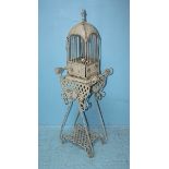 A 20th century 'shabby chic' painted metal bird cage on ornate matching stand, with scrolling and