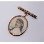 An oval portrait miniature depicting a Red Cross nurse, displayed in a yellow metal (tests as 9ct