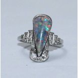 A white metal, opal and diamond ring, the top set with a drop-shaped opal and with diamonds to