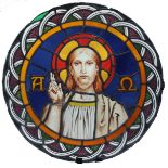 A 19th century stained and lead glazed circular panel, depicting Christ, flanked by Alpha and