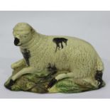 A late 18th Century Ralph Wood pottery figure of a recumbent sheep, decorated in coloured glazes,
