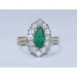 An 18ct gold, emerald and diamond ring, the centre claw set with an oval cut emerald, surrounded