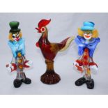 Two Murano glass clowns and a cockerel. Tallest figure measuring 32cm.