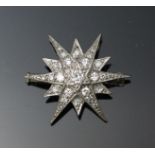 An 18ct white gold and diamond star brooch, the centre set with a solitaire diamond and surrounded