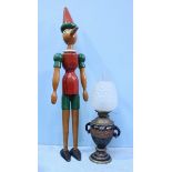 A painted wooden jointed Pinocchio, approximately 108cm high, together with an oil lamp (as found)