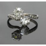 An Antique Two-Stone Diamond Ring of cross-over design, claw-set with two round Victorian-Cut