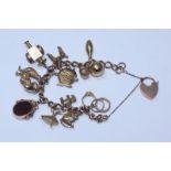 A 9ct gold charm bracelet with various charms including a lantern and a heart locket etc. Gross