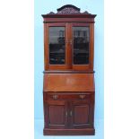 An Edwardian walnut bureau bookcase, the top with two glazed doors enclosing two shelves, above a