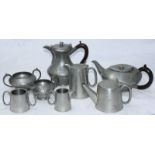 A four-piece planished pewter tea and coffee set comprising coffee pot, teapot, sugar bowl and