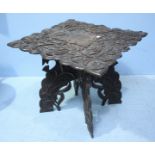 An Anglo-Indian profusely carved teak occasional table with scrolling foliate and thistle design,