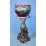 An Empress majolica pottery jardiniere and stand moulded with shells and scrollwork, in pink,