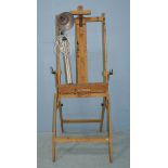 An adjustable wooden artists easel, together with an 'Industrial' style adjustable studio lamp.