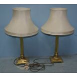 A pair of brass table lamps, the cream shades raised on classical style reeded columns to square