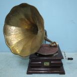 An HMV gramophone with embossed brass horn, stained-wood case, with winder, mechanism working (af)