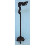 An early 20th century Chinese hardwood dragon lamp stand, raised on a carved column with four carved