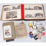 A collection of early 20th century postcards and newspaper clippings in album, together with a