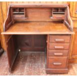 A 1920's stained oak roll-top desk, the fitted interior with drawers and pigeonholes, above a set of