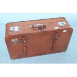 A vintage brown leather suitcase. 65cm wide.