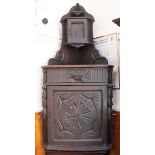 A Victorian carved and dark fumed oak standing corner cupboard with small cupboard to upper