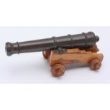 A small model of a canon, reputably made from a copper rivet and oak from H.M.S Victory. 21cm long.