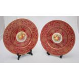 A pair of Royal Worcester cabinet plates, the central roundels painted with bunches of fruit, one