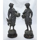 A pair of patinated spelter figures modelled as a boy and girl carrying fowl and a rabbit etc,