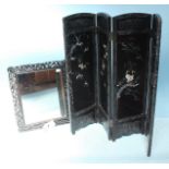 An Oriental carved folding screen with four framed black lacquer panels inlaid with mother of