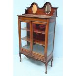 A Regency reproduction mahogany two door display cabinet, the raised back with two oval bevelled