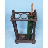 A cast iron umbrella stand with three holes to top, raised on reeded supports to drip-pan. 62cm