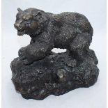 A large cast bronze sculpture of a bear on a rock, stamped P J Mene, approximately 34cm x 37cm wide