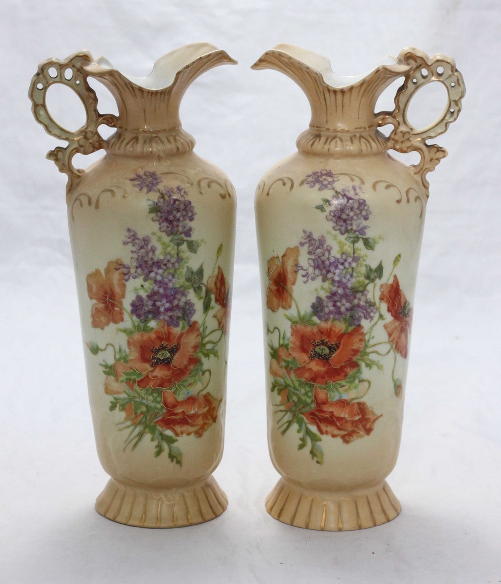 A pair of Victorian Carlsbad Austrian blush ivory ewers with shaped rims and pierced handles, red