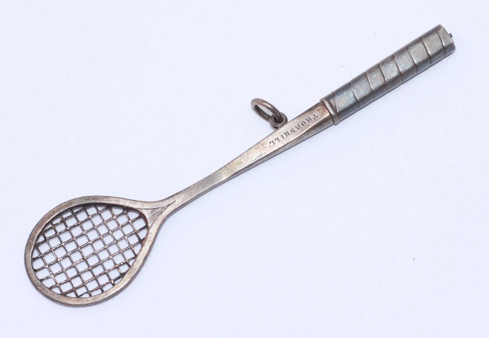 A novelty white metal propelling pencil modelled as a tilt-head lawn tennis racquet, unmarked but