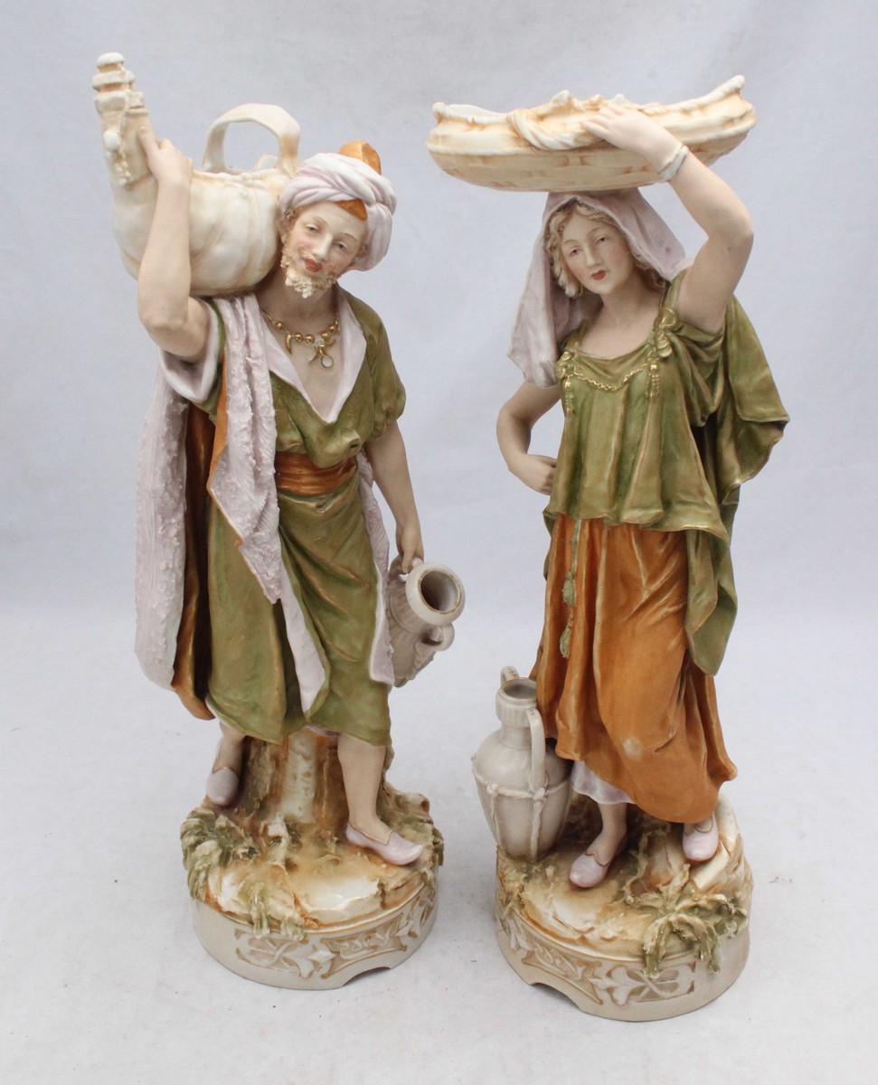 A pair of 19th century Royal Dux porcelain figures of a male and female Persian water carrier,