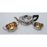 An Edwardian three-piece silver tea set comprising teapot, cream and sugar bowl, of serpentine shape