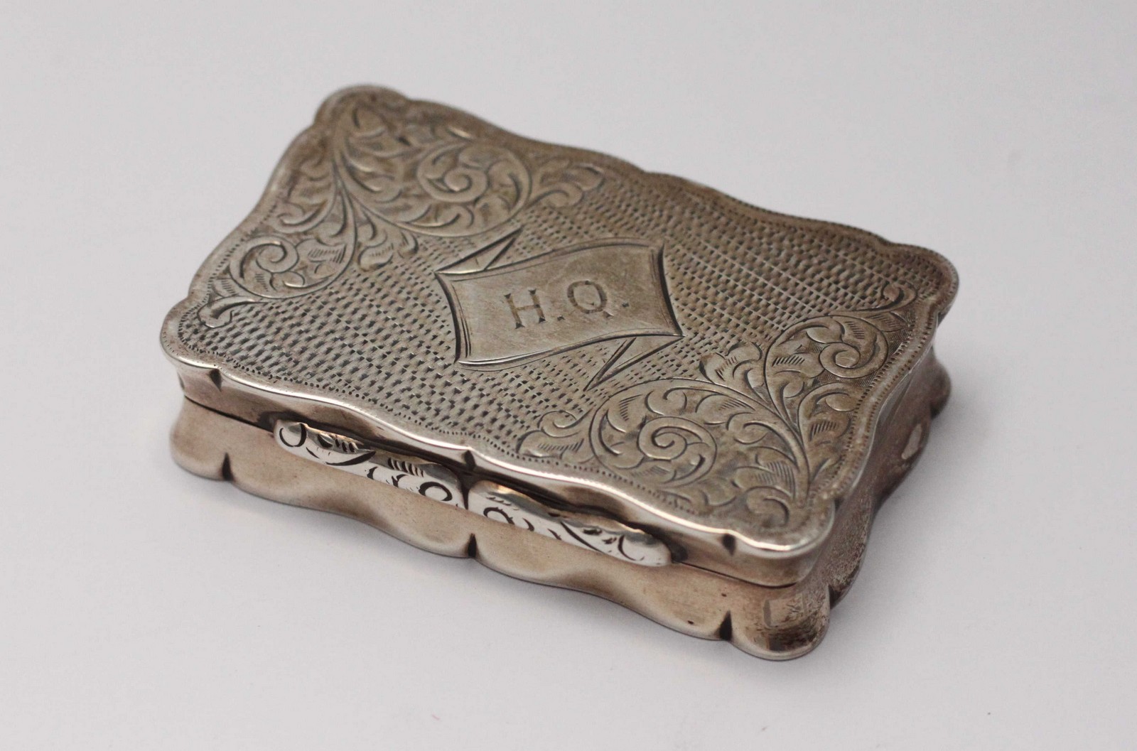 A 19th century silver snuff box of rectangular form with hinged cover, engine turned and engraved