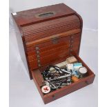A 20th century wooden mobile dental cabinet and contents, with roll-top revealing a drawer, six