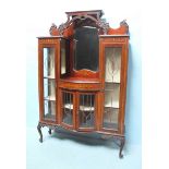 An early 20th century mahogany display cabinet, with a raised back to a central mirror, above two