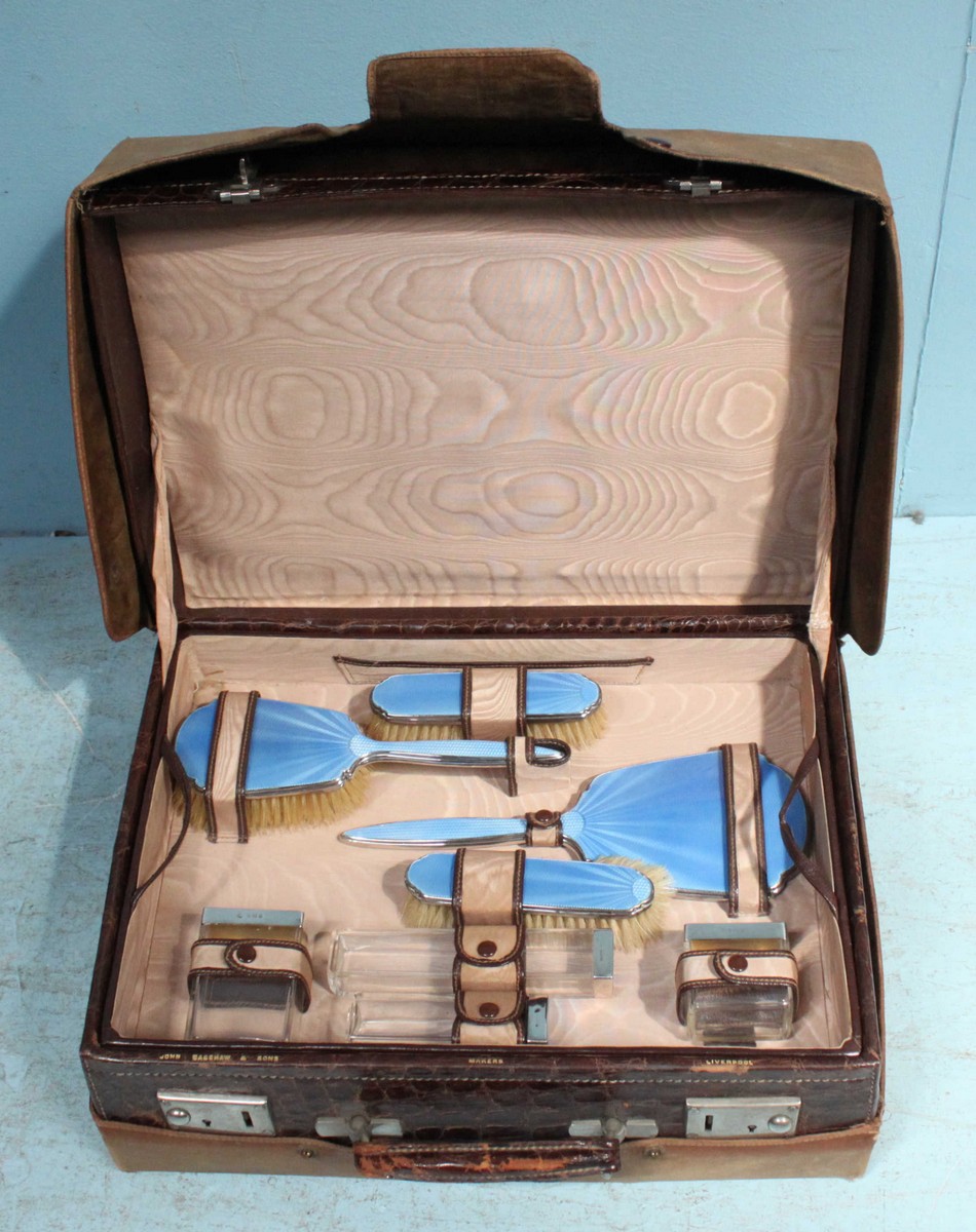 A ladies' eight-piece travelling dressing table set by 'Adie Bros', comprising of three silver and