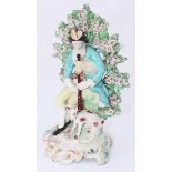 An 18th century Chelsea Derby porcelain figure of a seated man playing bagpipes, with a dog at his