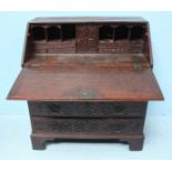 A 19th century carved and dark fumed oak bureau, with sloped front carved with cherubs riding