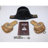 A Naval cocked hat, a pair of gold epaulettes and a copy of 'The Royal Navy Officer's Pocket-Book