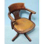 A 1920's oak revolving office chair with tan leather seat.