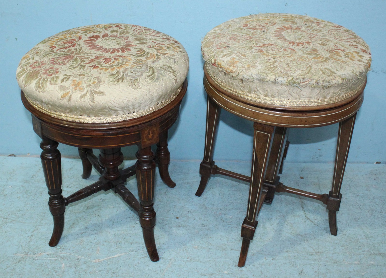 Two various inlaid mahogany revolving piano stools, each with cream, floral upholstered seats.