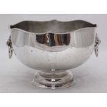 A large silver plated ice bucket with gadrooned shaped rim and lion mask handles on circular
