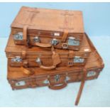 A set of three Giovanni style graduated tan suitcases with leather strapping, the largest 45x75cm