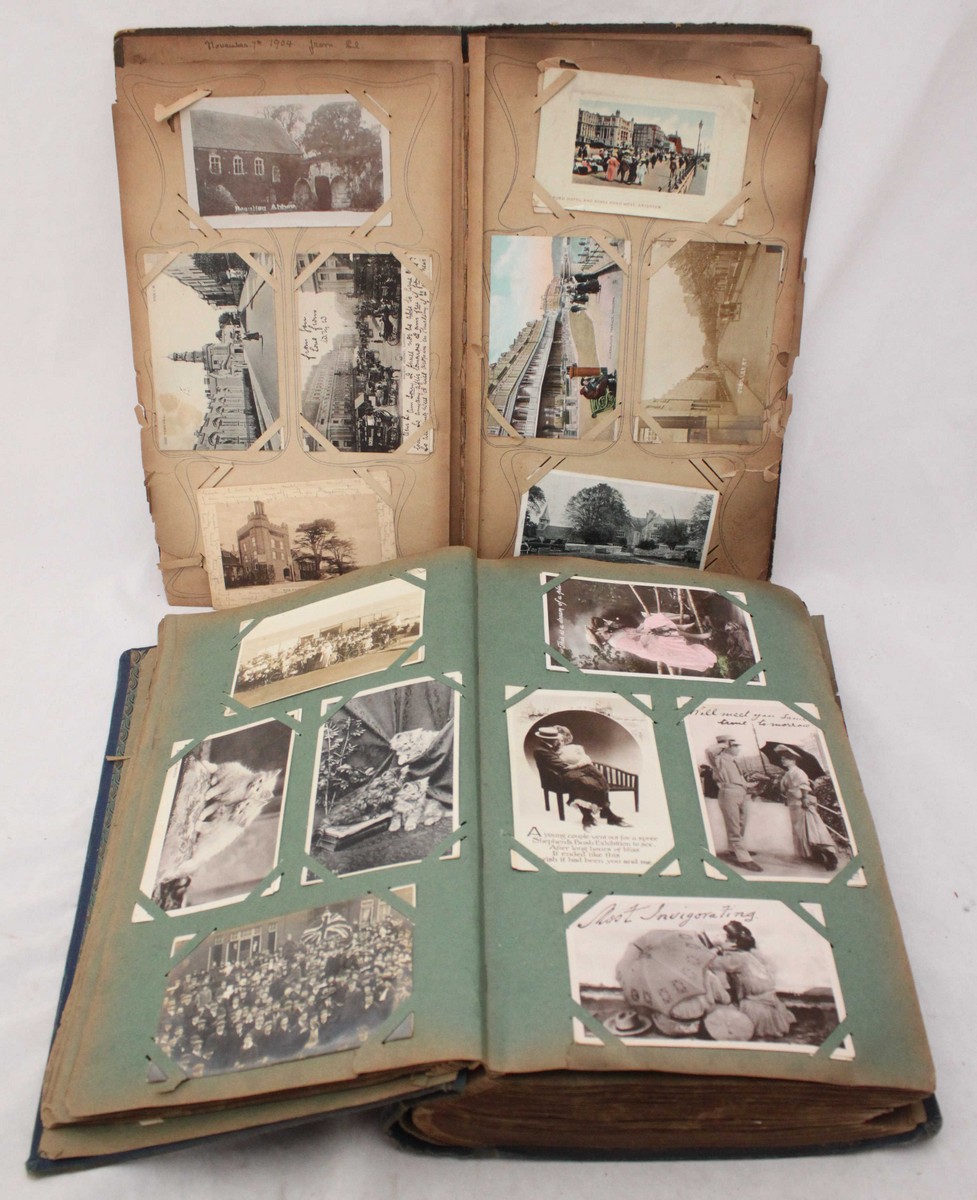 A collection of early 20th century postcards, in two albums, including printed and photographic